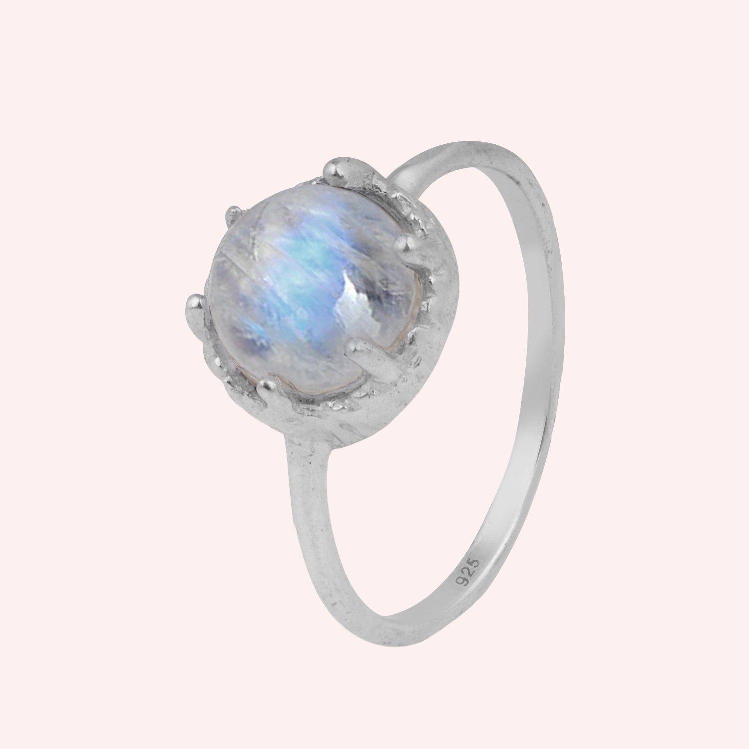 Solitaire_ring_in_sterling_ring_with_round_moonstone_shown_in_slightly_angled_view_on_solid_pink_background