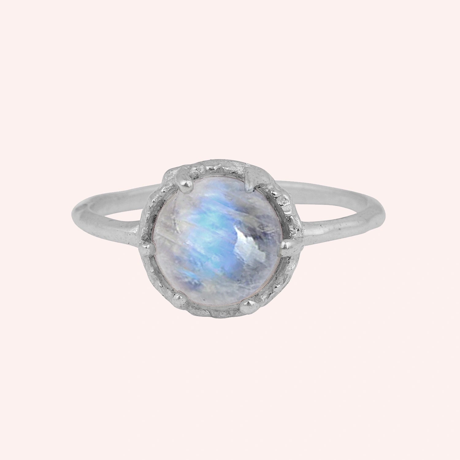 Solitaire_ring_in_sterling_ring_with_round_moonstone_shown_in_front_angle_view_on_solid_pink_background