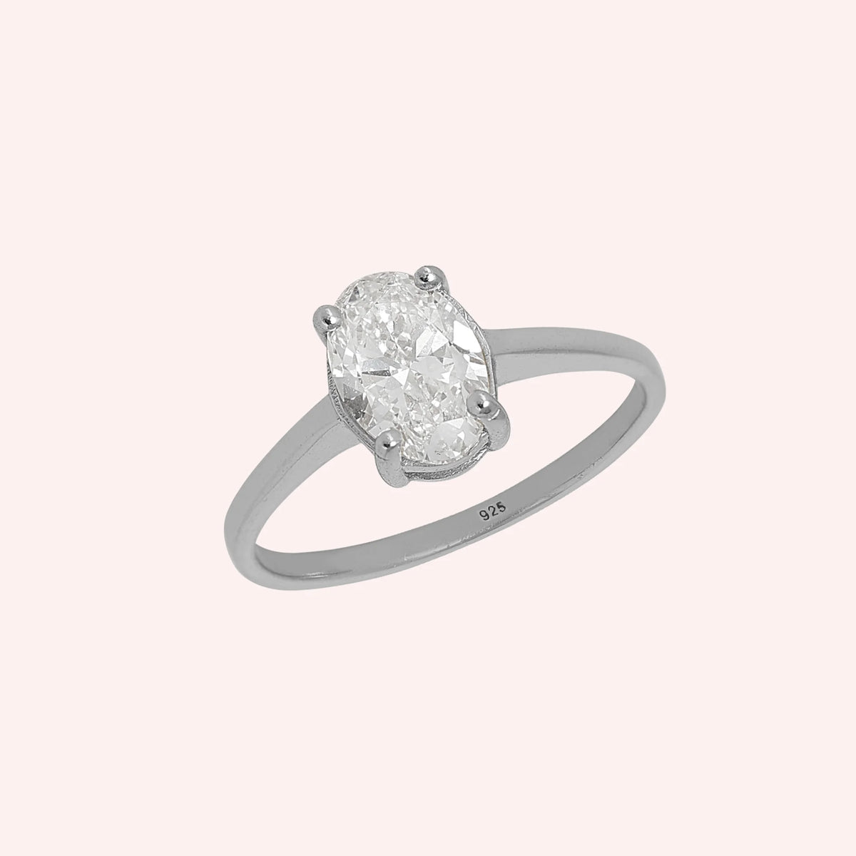 Solitaire_ring_in_sterling_silver_with_an_oval_CZ_stone_at_side_angle_view_on_solid_pink_background