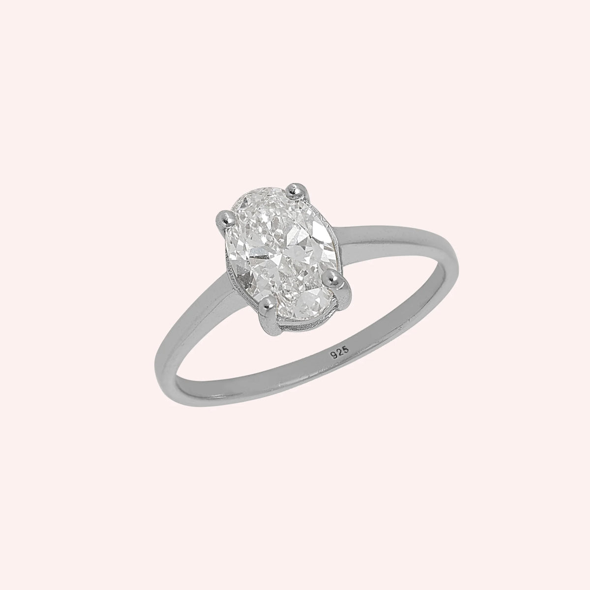 Solitaire_ring_in_sterling_silver_with_an_oval_lab_grown_diamond_at_slightly_angle_view_on_solid_pink_background
