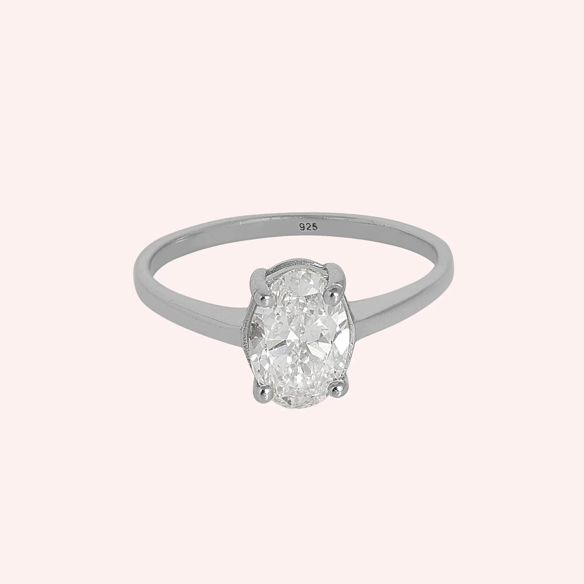 Solitaire_ring_in_sterling_silver_with_an_oval_CZ_stone_at_front_angle_view_on_solid_pink_background