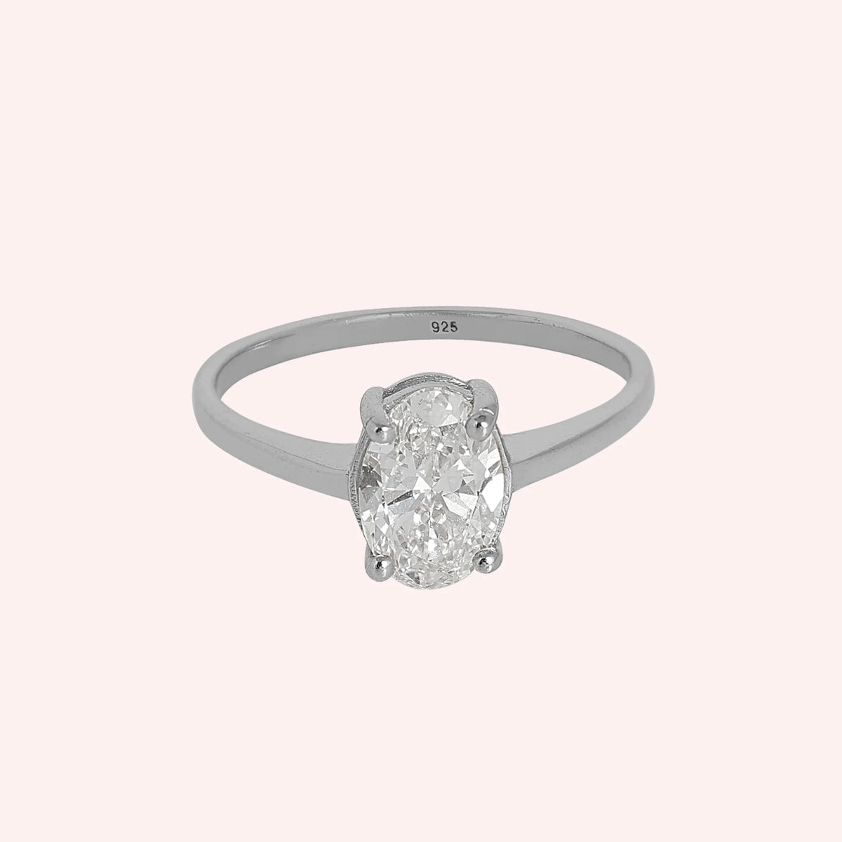 Solitaire_ring_in_sterling_silver_with_an_oval_lab_grown_diamond_at_front_angle_view_on_solid_pink_background