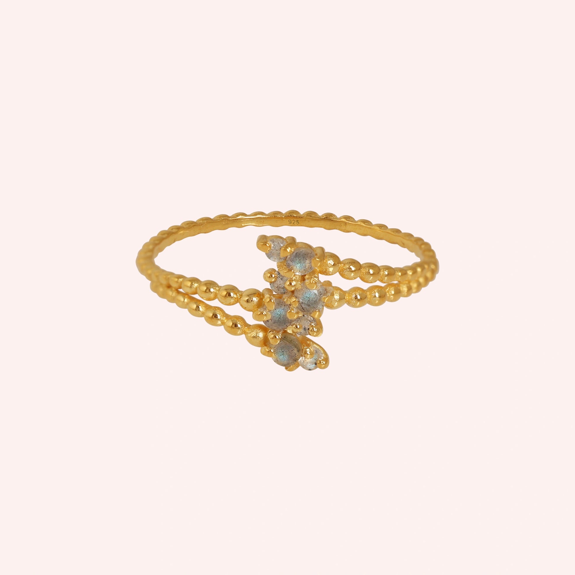 Spiral_ring_with_gold_plated_silver_bubble_band_and_labradorite_stones_at_front_angle_view_on_solid_pink_background