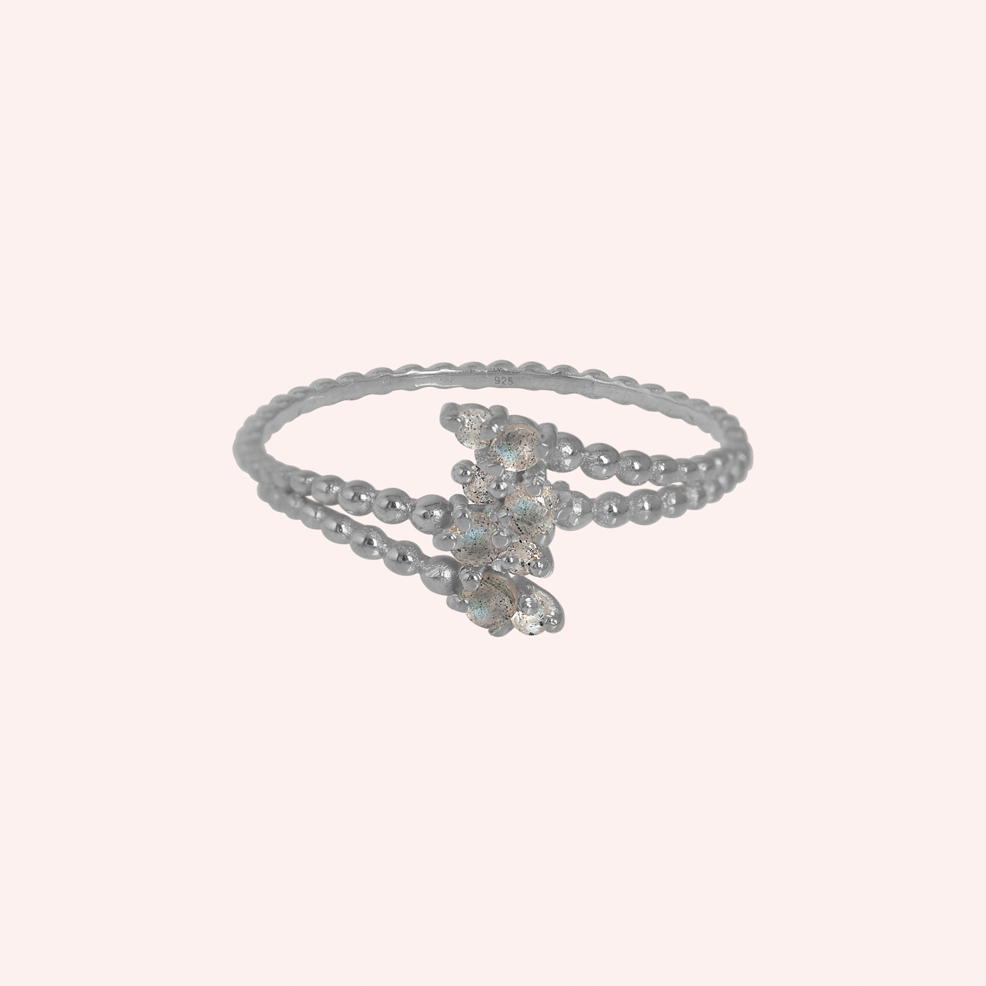 Spiral_ring_with_sterling_silver_bubble_band_and_labradorite_stones_at_front_angle_view_on_solid_pink_background
