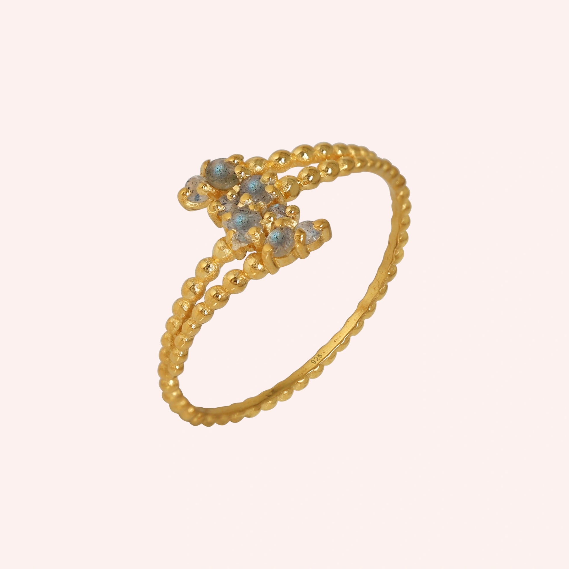 Spiral_ring_with_gold_plated_silver_bubble_band_and_labradorite_stones_at_side_angle_view_on_solid_pink_background