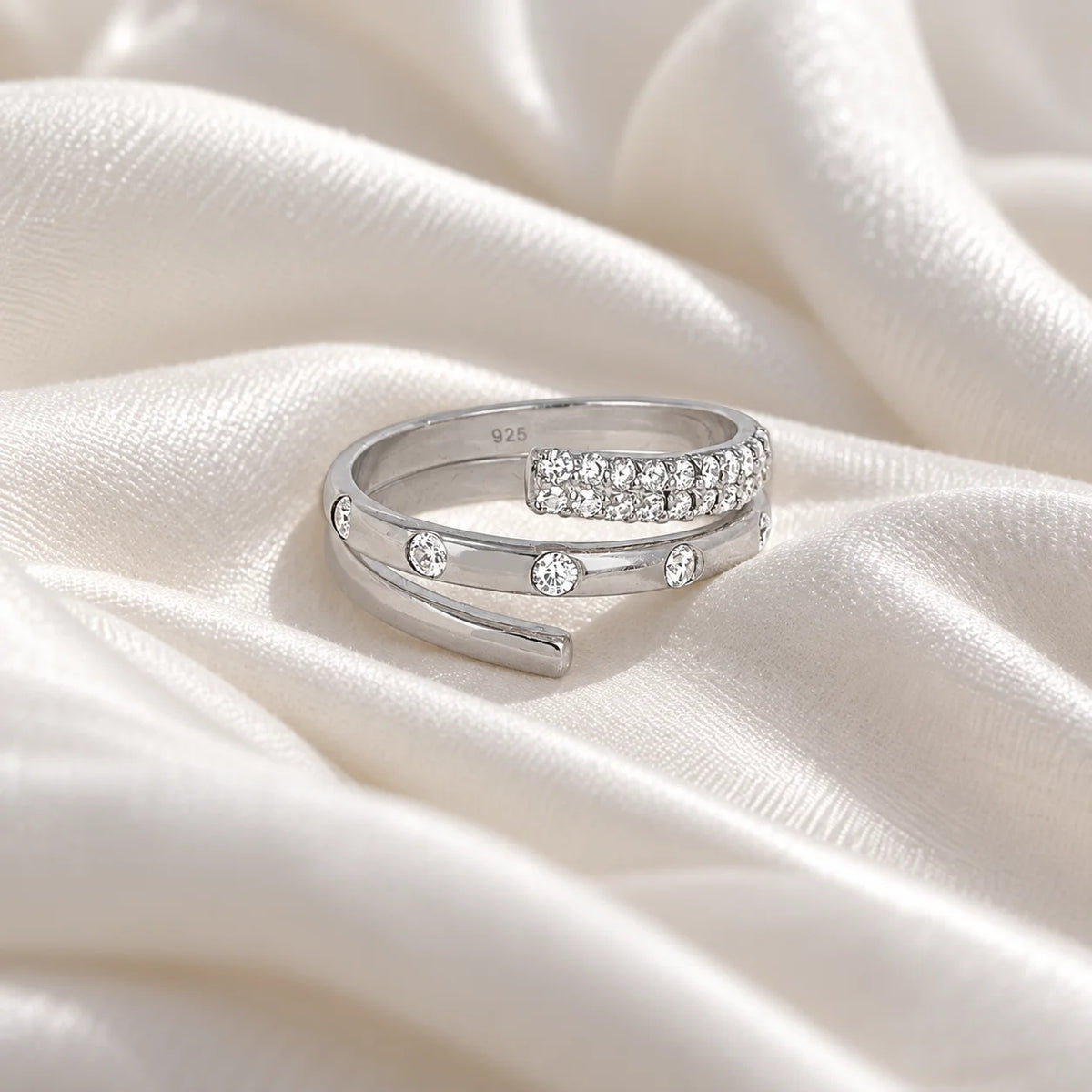 Spiral_ring_in_sterling_silver_with_lab_grown_diamonds_at_front_angle_view_on_soft_fabric_background