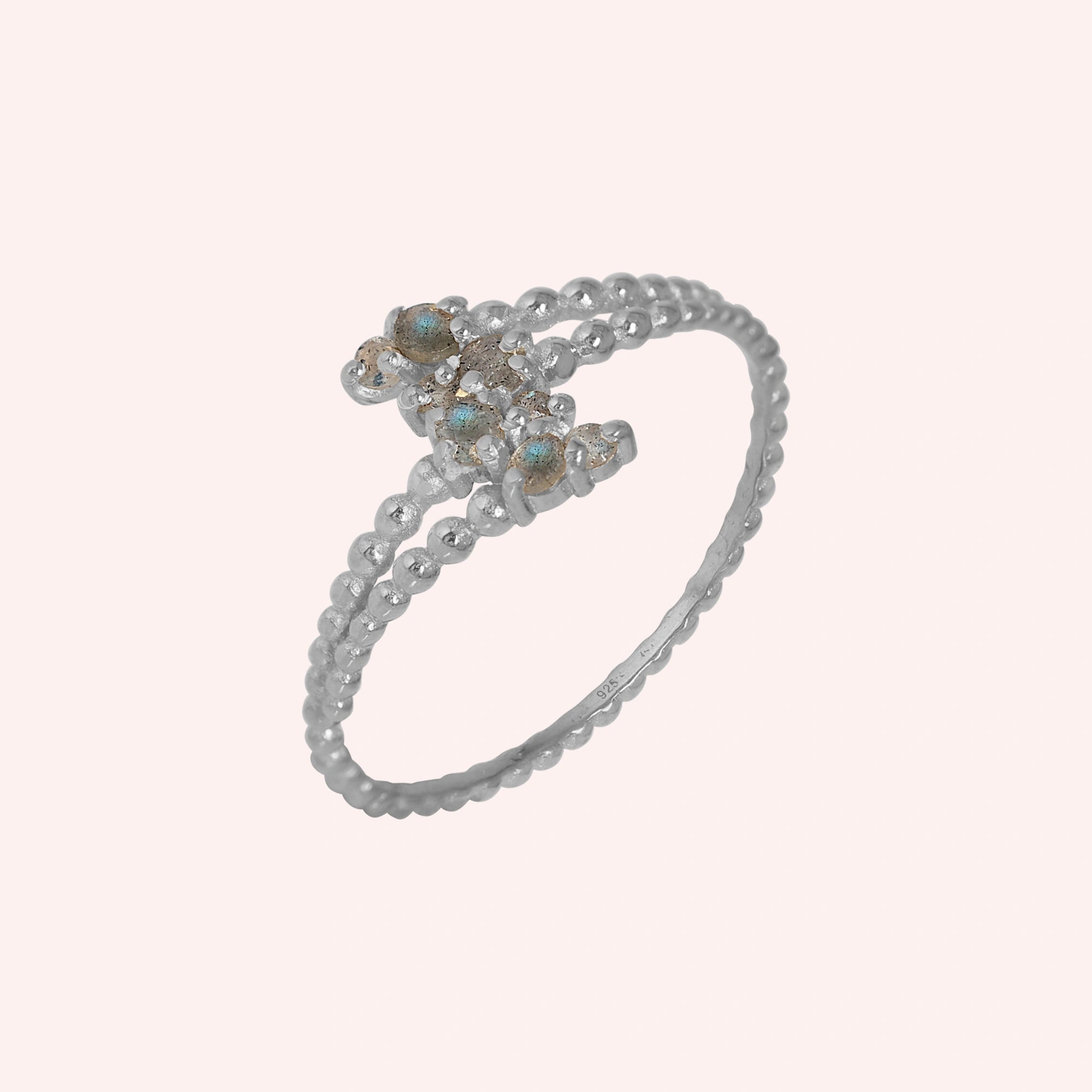 Spiral_ring_with_sterling_silver_bubble_band_and_labradorite_stones_at_side_angle_view_on_solid_pink_background