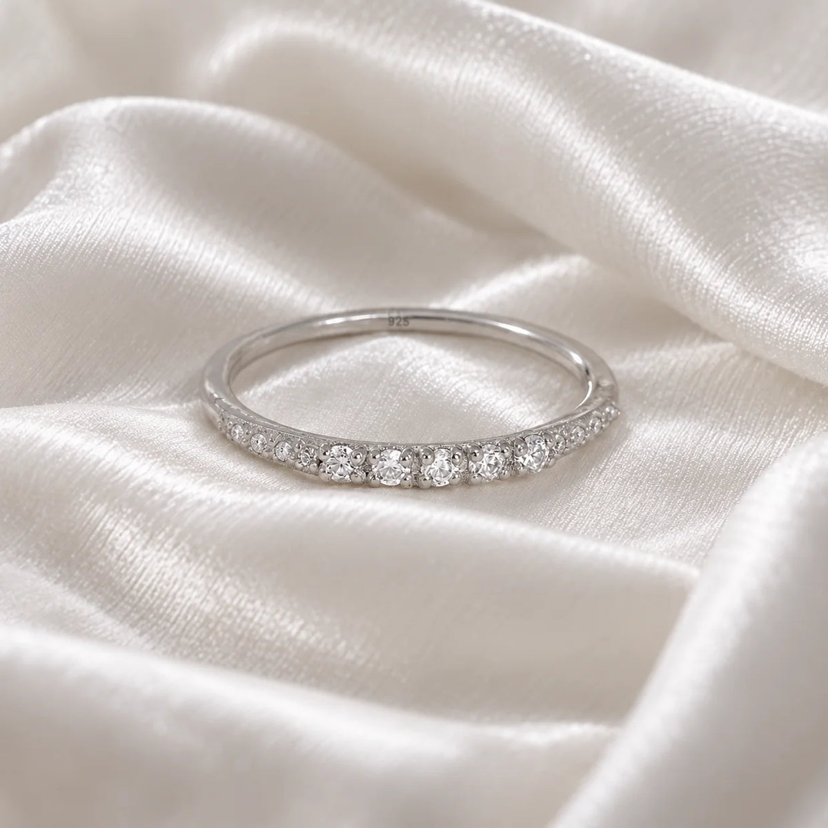 Stackable_ring_in_sterling_silver_with_CZ_stones_at_front_angle_view_on_soft_fabric_background