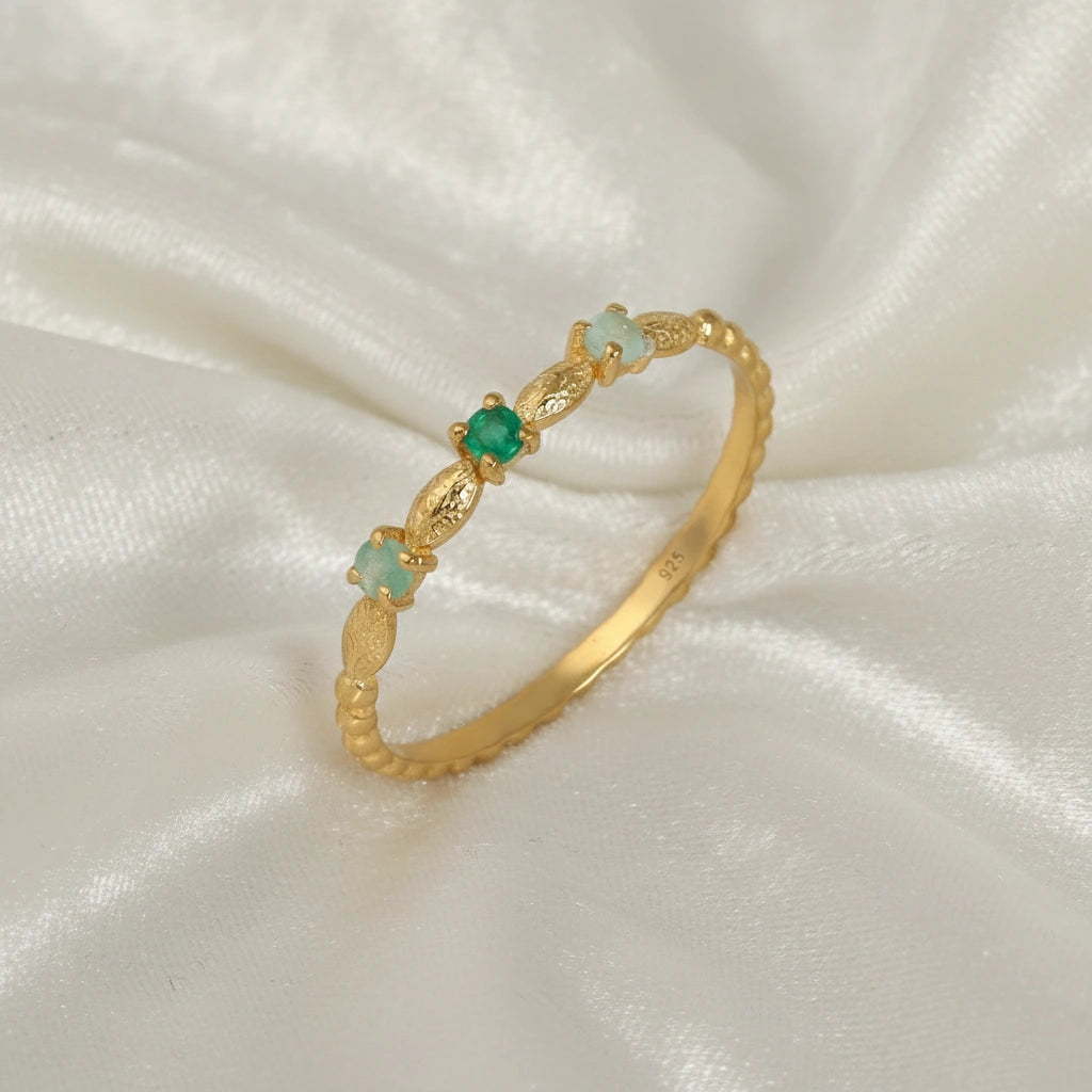 Stackable-ring-with-green-gemstones-gold-plated-silver-angled-view-on-white-satin-background