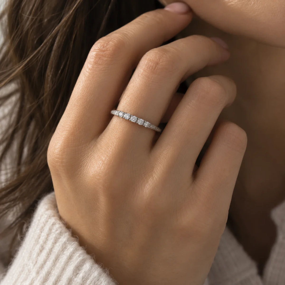 Stackable_ring_in_sterling_silver_with_CZ_stones_at_front_angle_view_worn_by_a_model