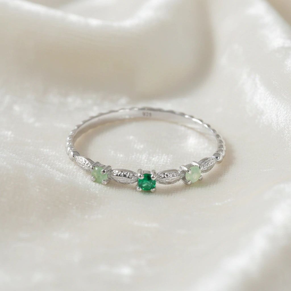 Stackable-ring-with-green-gemstones-sterling-silver-front-view-on-white-satin-background