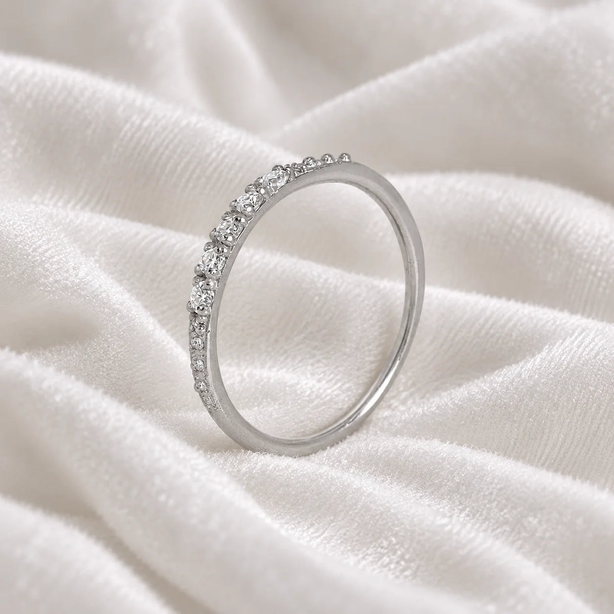 Stackable_ring_in_sterling_silver_with_lab_grown_diamonds_at_side_angle_view_on_soft_fabric_background