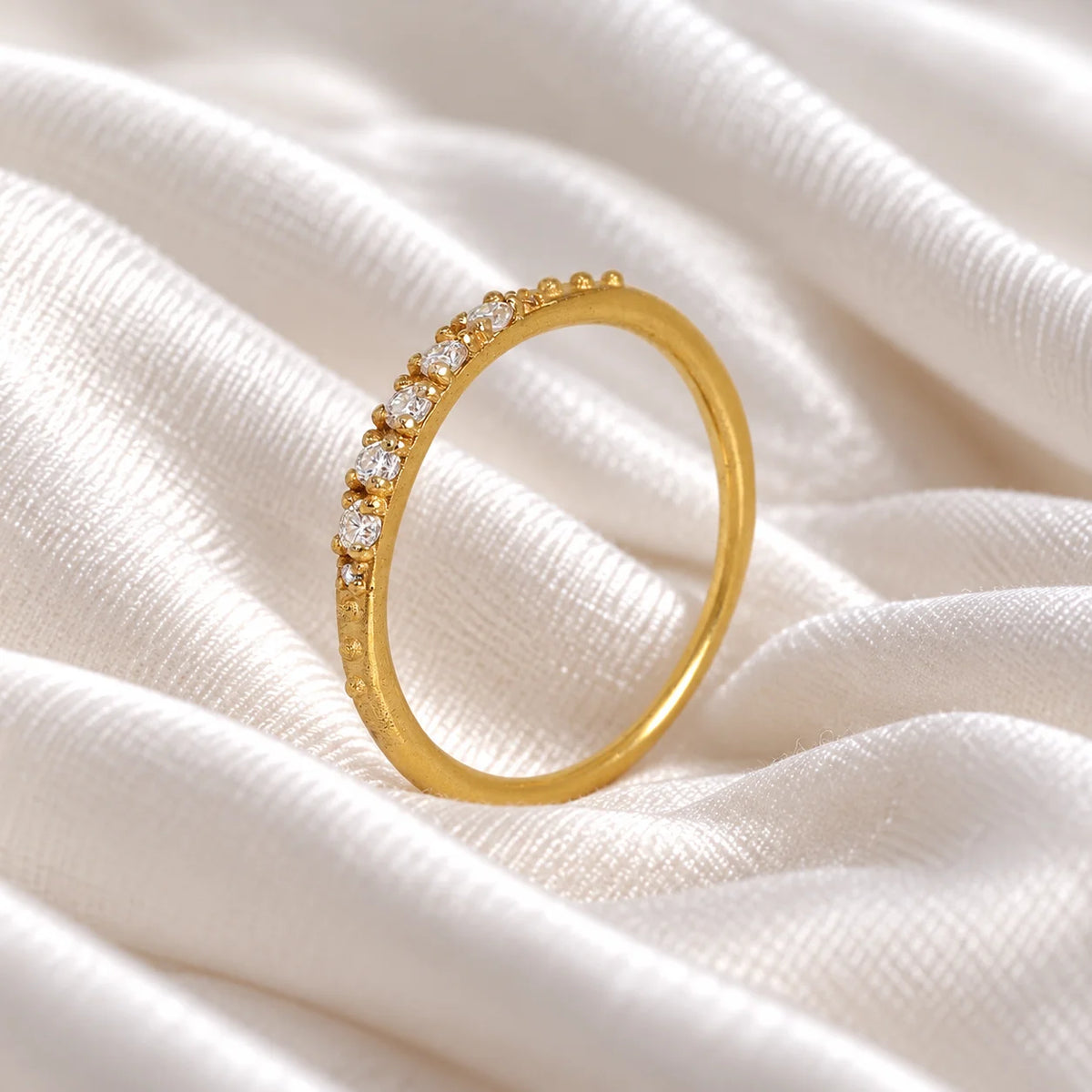 Stackable_ring_in_gold_plated_silver_with_lab_grown_diamonds_at_side_angle_view_on_soft_fabric_background