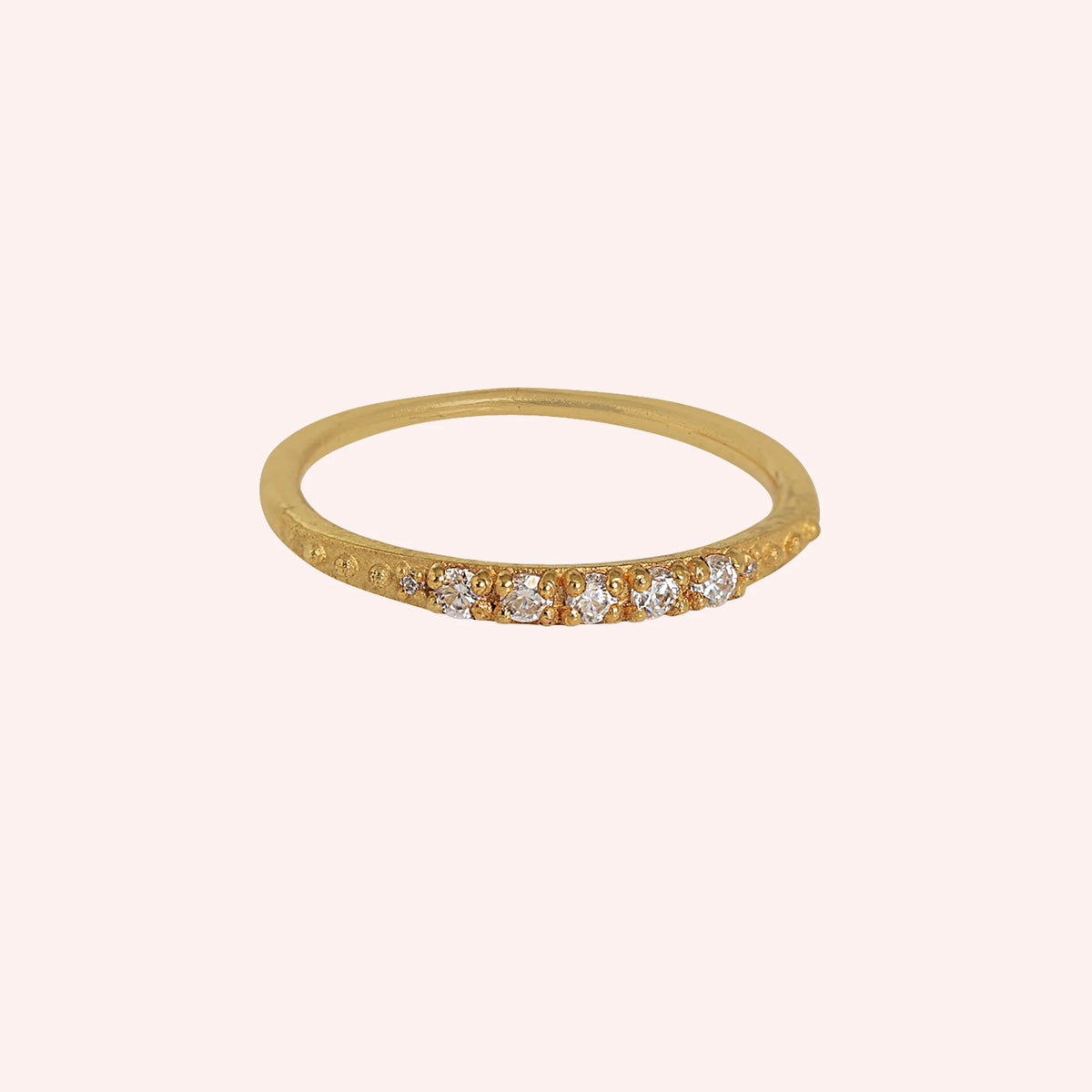 Stackable_ring_in_gold_plated_silver_with_CZ_stones_at_front_angle_view_on_solid_pink_background