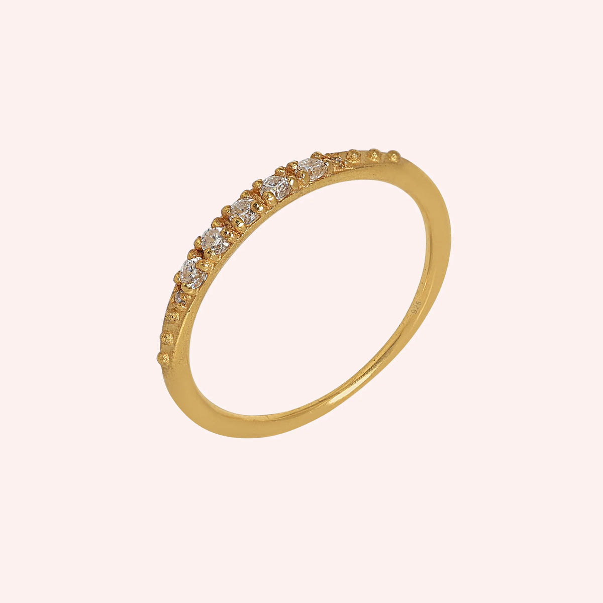 Stackable_ring_in_gold_plated_silver_with_CZ_stones_at_side_angle_view_on_solid_pink_background