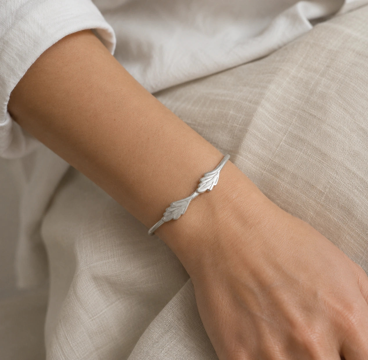Stacking_bracelet_in_sterling_silver_with_a_leaf_design_band_worn_by_a_model