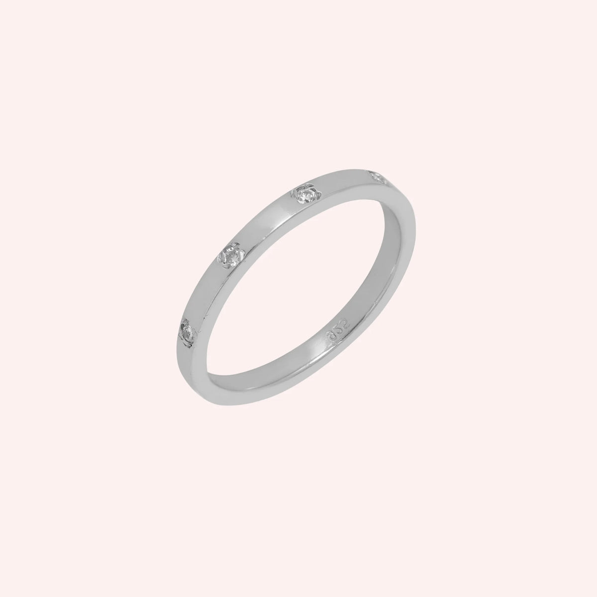 Stacking_ring_in_sterling_silver_with_lab_grown_diamonds_at_slight_angle_view_on_solid_pink_background