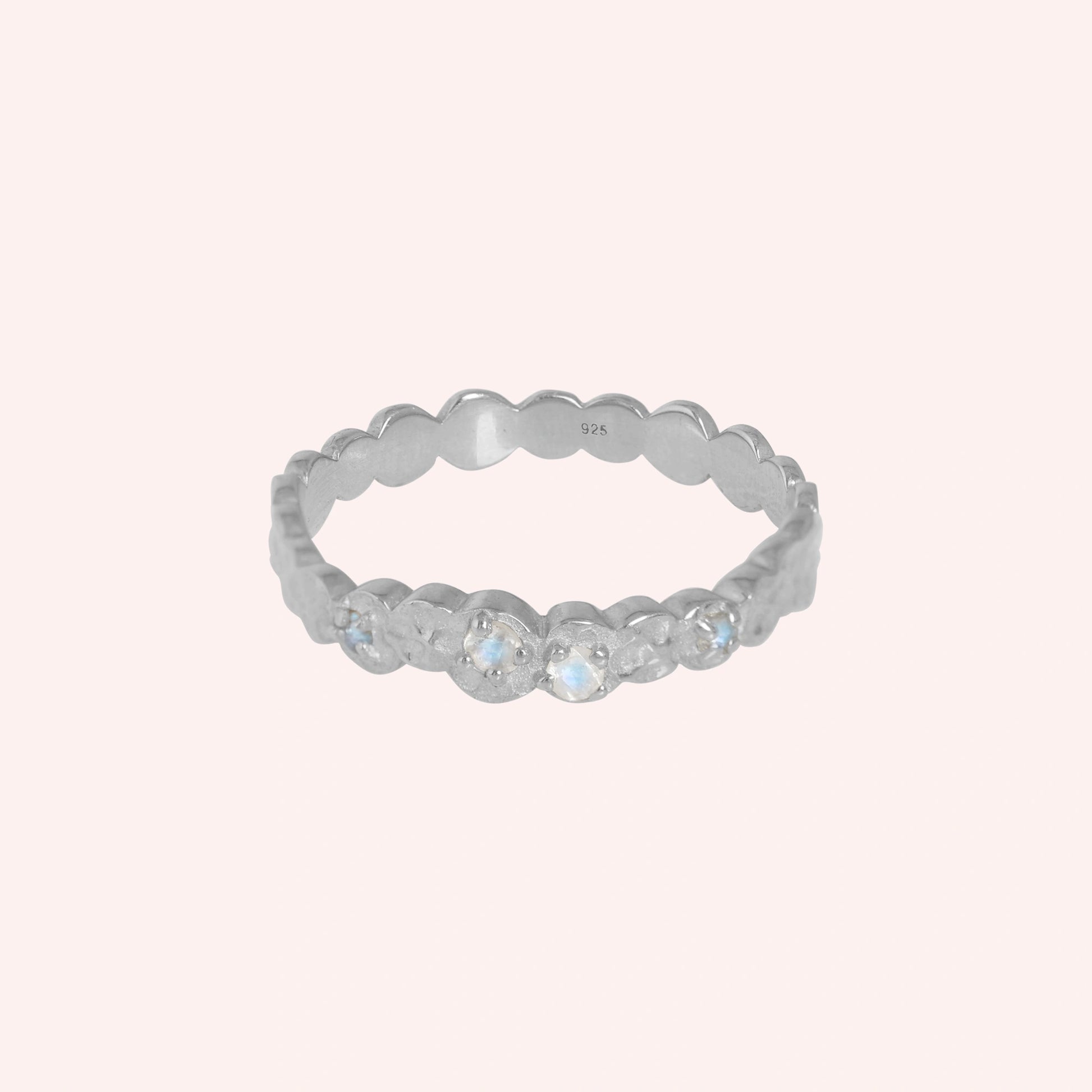 Stacking_ring_in_sterling_silver_textured_band_with_moonstones_in_front_angled_view_on_solid_backgroundpink