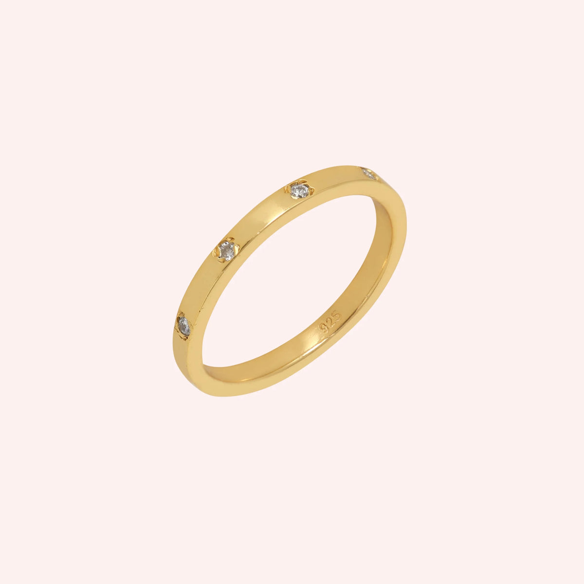 Stacking_ring_in_gold_plated_silver_with_lab_grown_diamonds_at_slight_angle_view_on_solid_pink_background