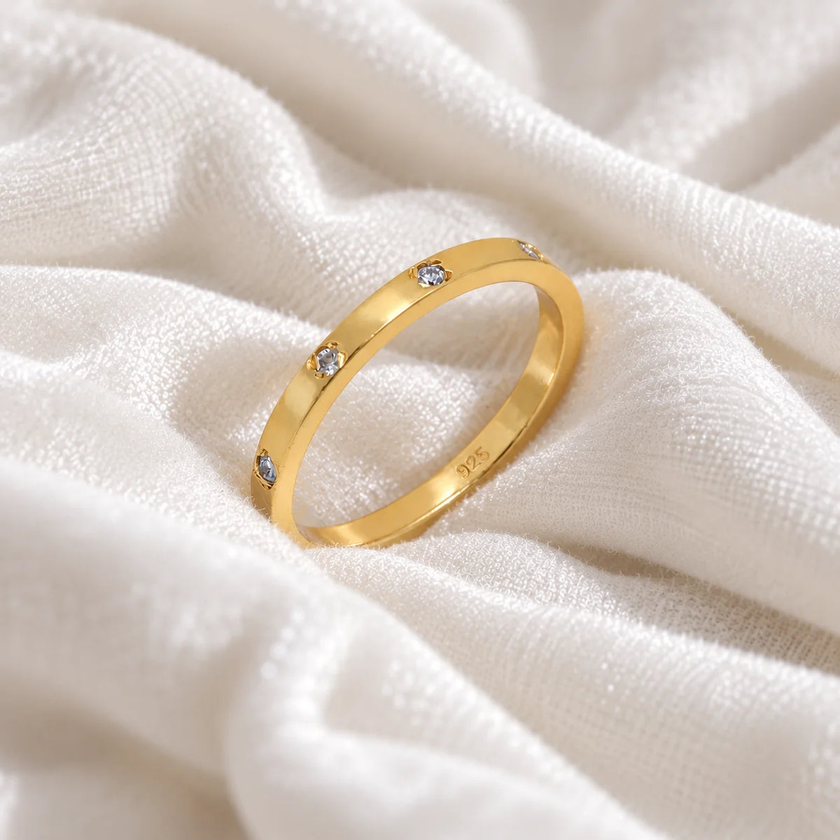 Stacking_ring_in_gold_plated_silver_with_lab_grown_diamonds_at_slight_angle_view_on_soft_fabric_background