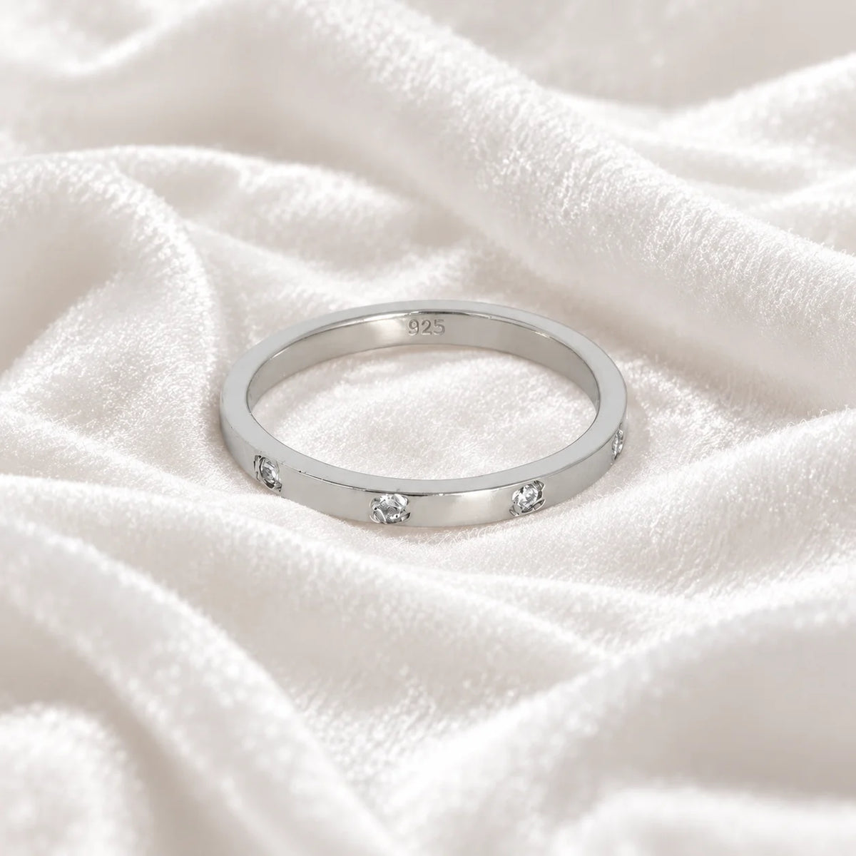 Stacking_ring_in_sterling_silver_with_lab_grown_diamonds_at_front_angle_view_on_soft_fabric_background