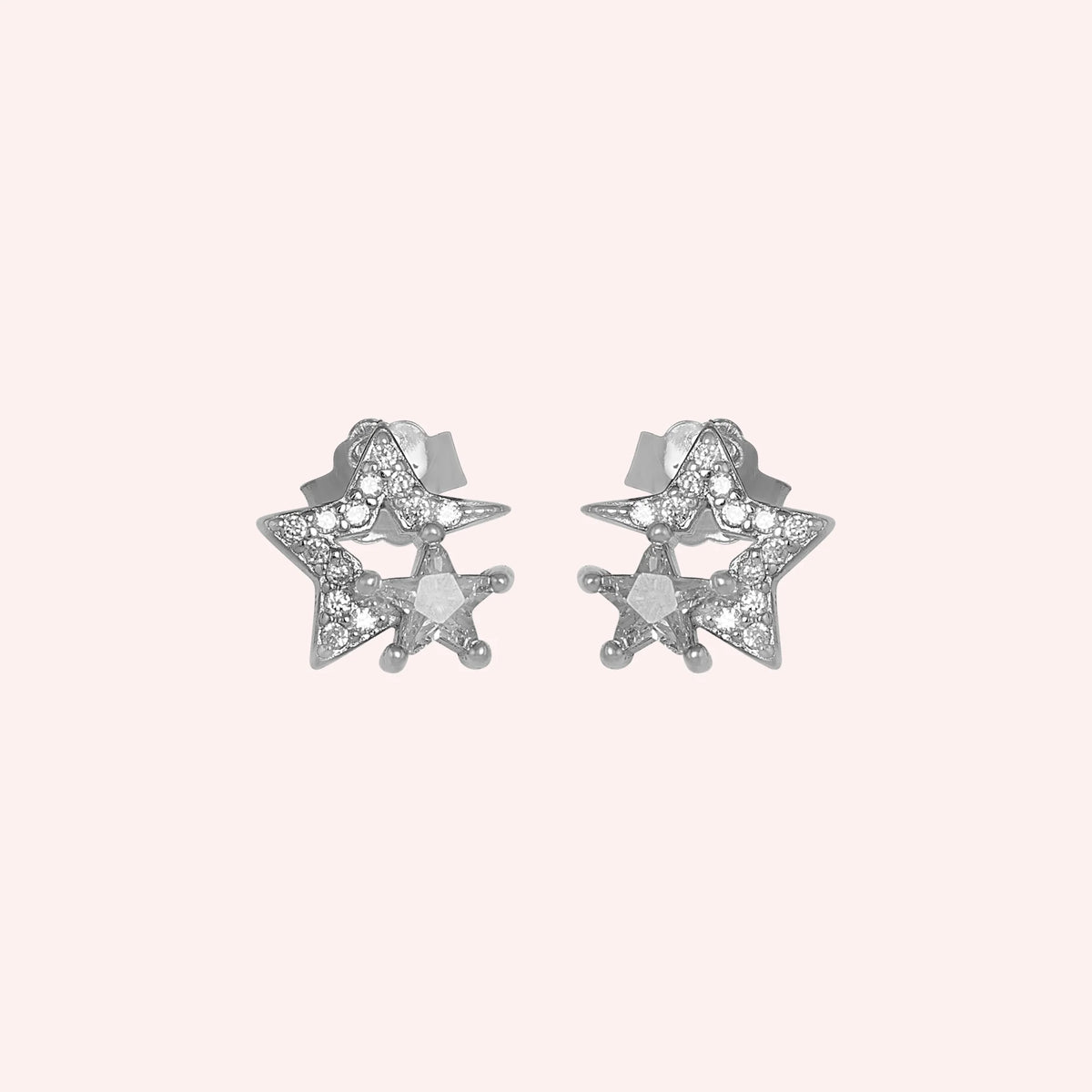 Star_earrings_in_sterling_silver_with_CZ_stones_at_front_angle_view_on_solid_pink_background