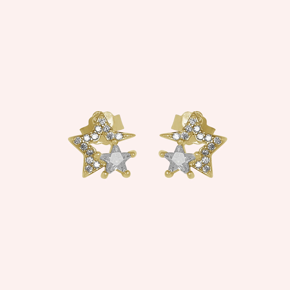 Star_earrings_in_gold_plated_silver_with_CZ_stones_at_front_angle_view_on_solid_pink_background