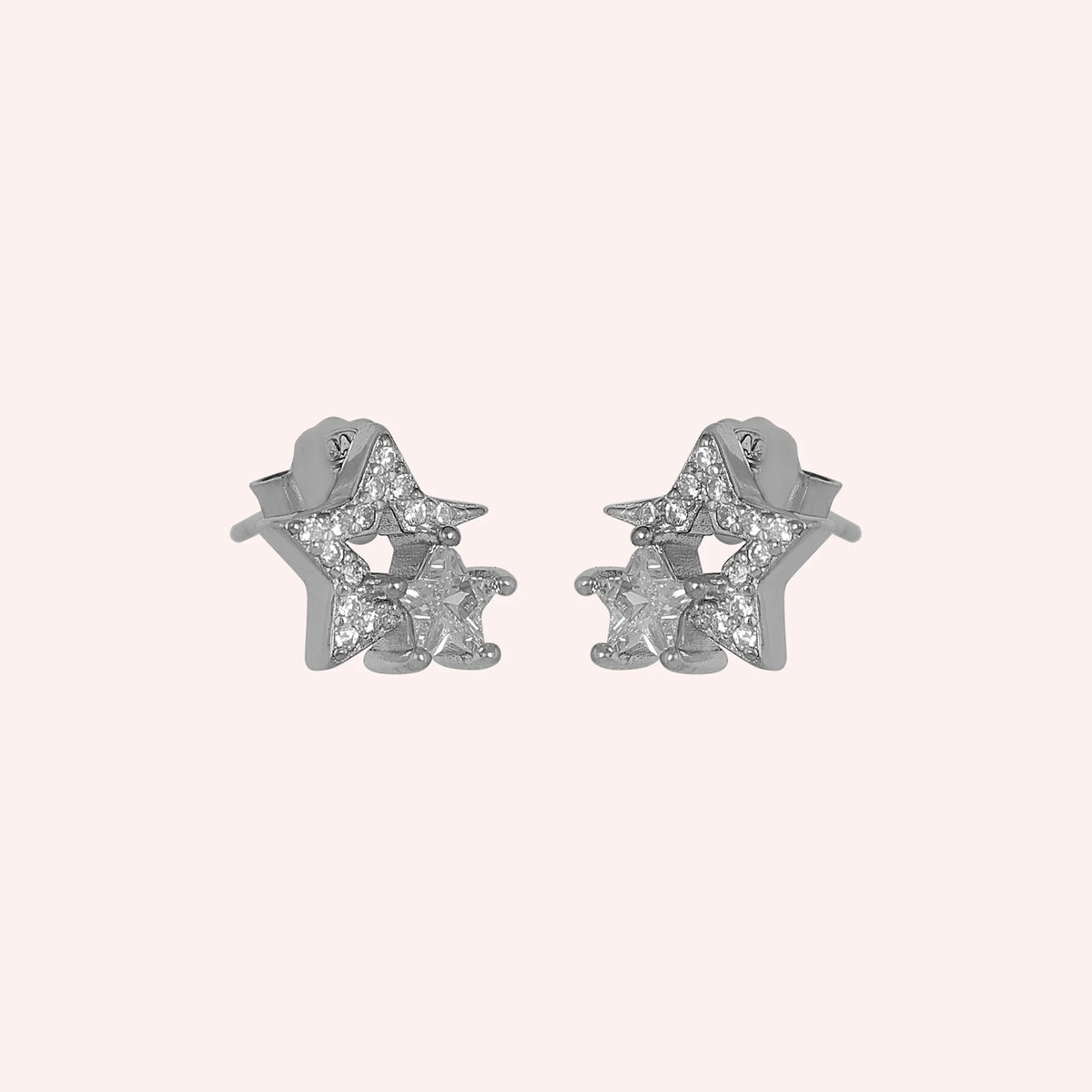 Star_earrings_in_sterling_silver_with_CZ_stones_at_side_angle_view_on_solid_pink_background
