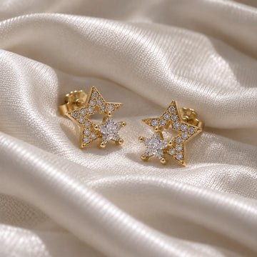 Star_earrings_in_gold_plated_silver_with_CZ_stones_at_side_angle_view_on_soft_fabric_background