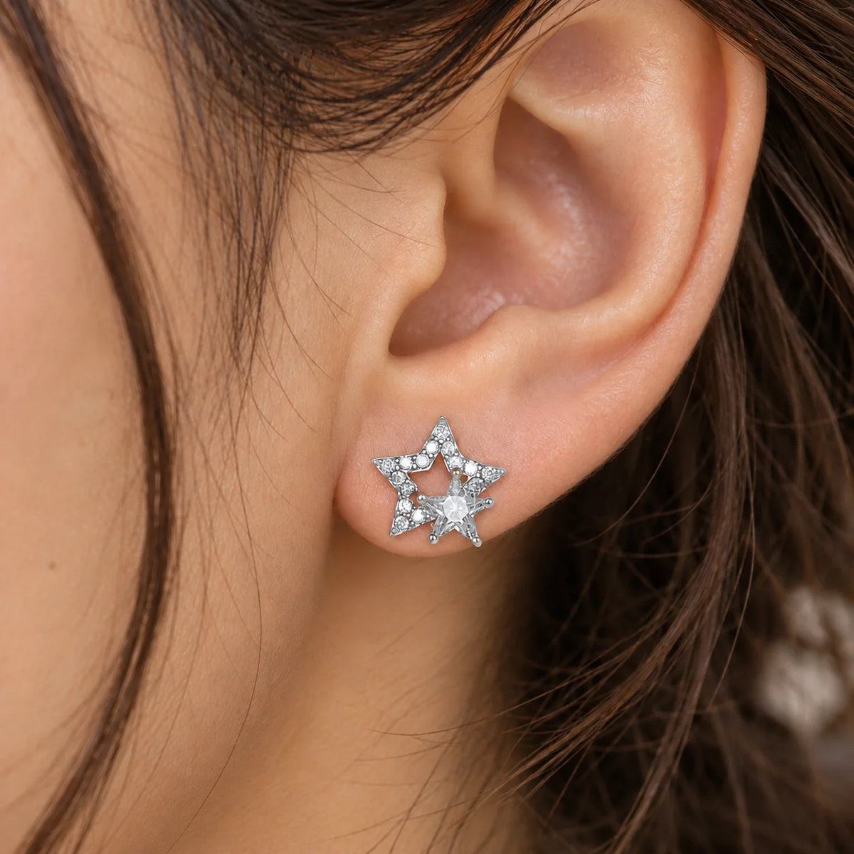 Star_earrings_in_sterling_silver_with_CZ_stones_at_front_angle_view_worn_by_a_model