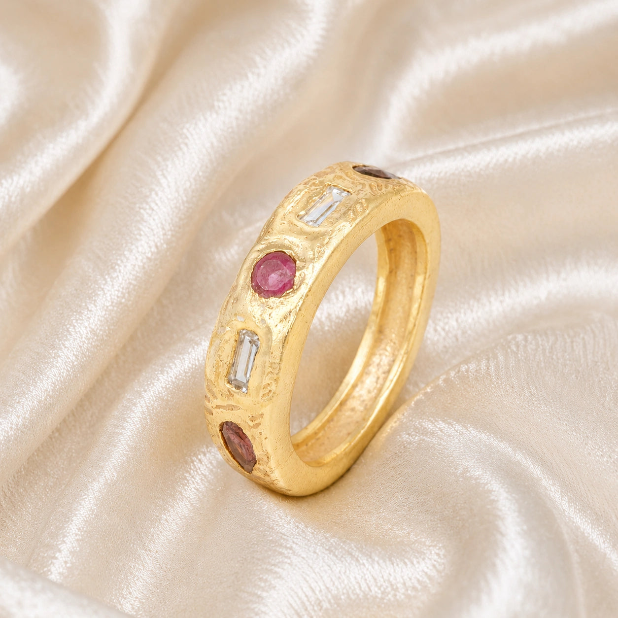 Statement_ring_in_gold_plated_silver_at_slightly_angled_view_with_multi_stones_on_a_soft_fabric_background