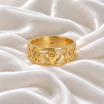 Statement_ring_in_gold_plated_silver_with_claddagh_design_band_at_front_angle_view_on_soft_fabric_background