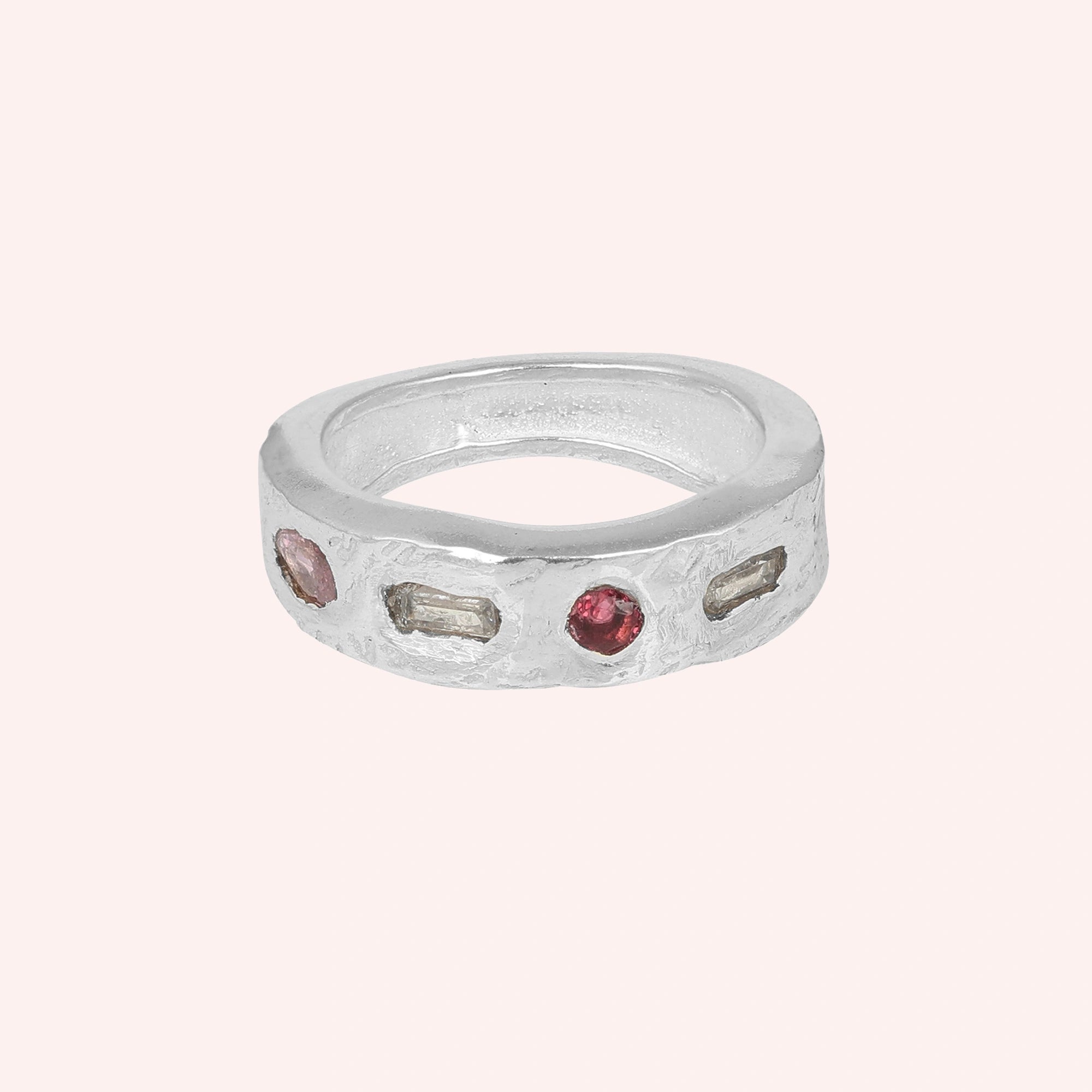 Statement_ring_in_sterling_silver_at_front_angle_with_multi_stones_on_a_solid_pink_background