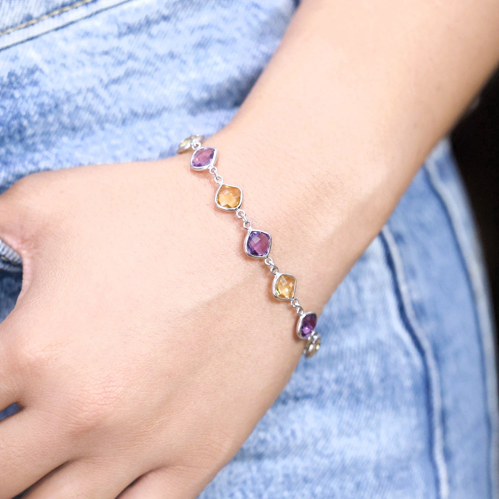 sterling_silver_gemstone_bracelet_side_angle_amethyst_citrine_bracelet_worn_on_wrist_with_denim_background