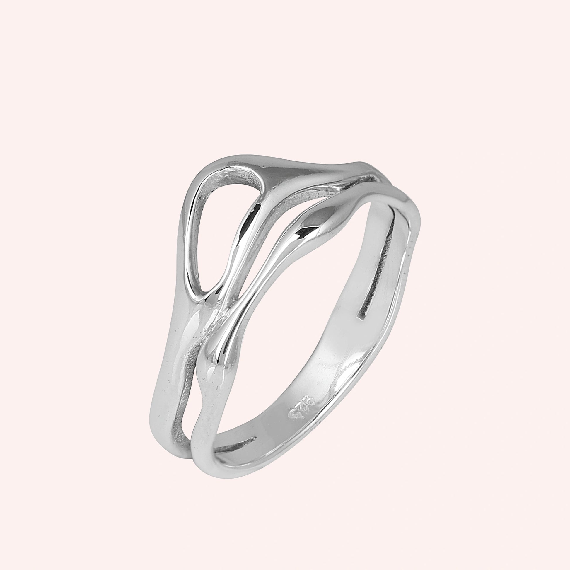 A side angle view of sterling silver rings for women on a pink background featuring a smooth and polished wave band ring design