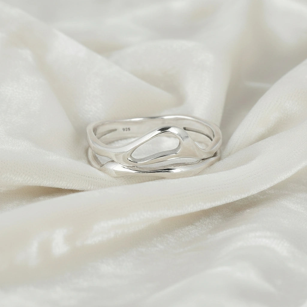 A front angle of a polished wave band ring on a white velvet background as a classic sterling silver rings for women's accessories