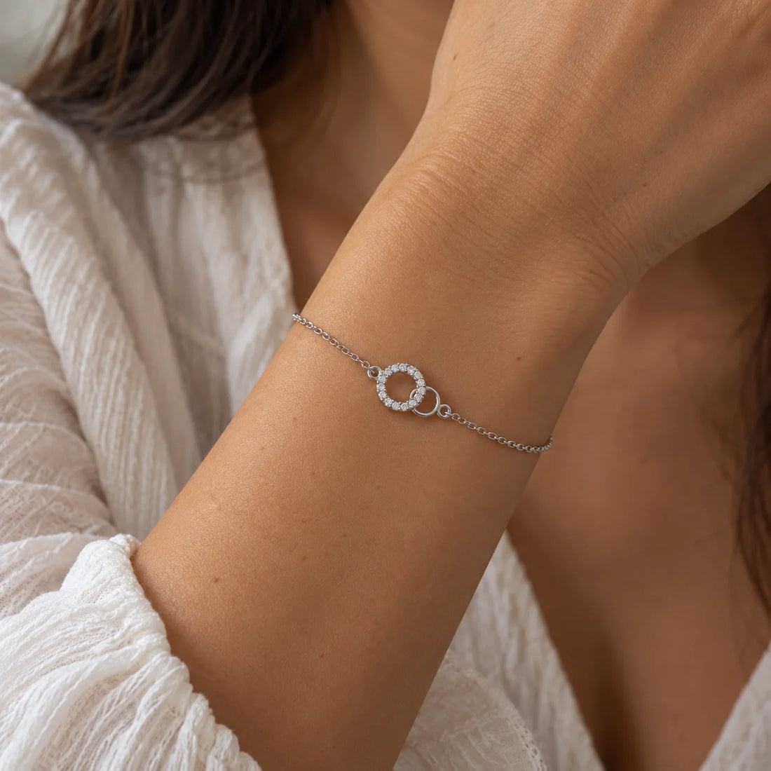 Stone_bracelet_in_gold_plated_silver_in_an_interlocking_design_at_front_angle_view_on_soft_fabric_background