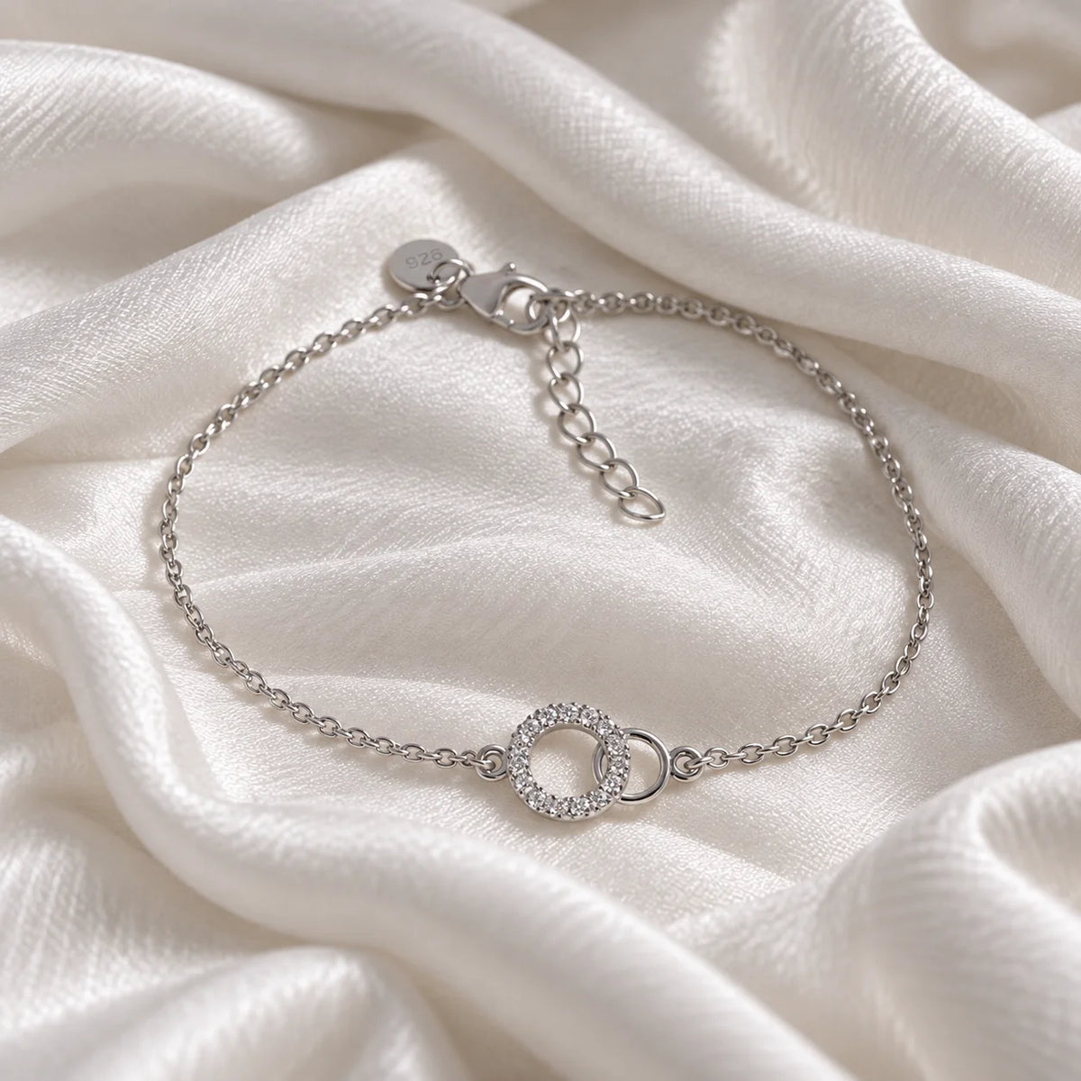 Stone_bracelet_in_sterling_silver_in_an_interlocking_design_at_front_angle_view_on_soft_fabric_background