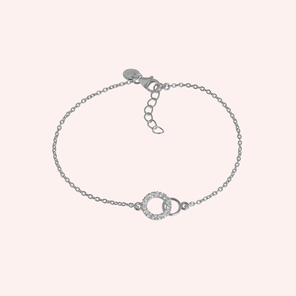 Stone_bracelet_in_sterling_silver_in_an_interlocking_design_at_front_angle_view_on_solid_pink_background