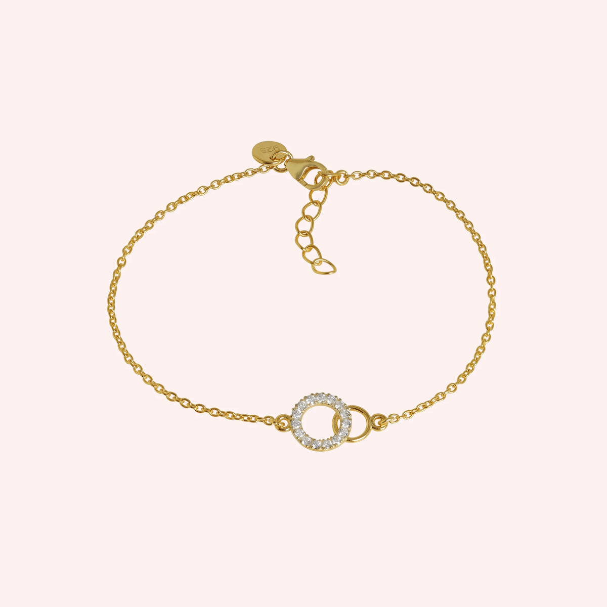 Stone_bracelet_in_gold_plated_silver_in_an_interlocking_design_at_front_angle_view_on_solid_pink_background