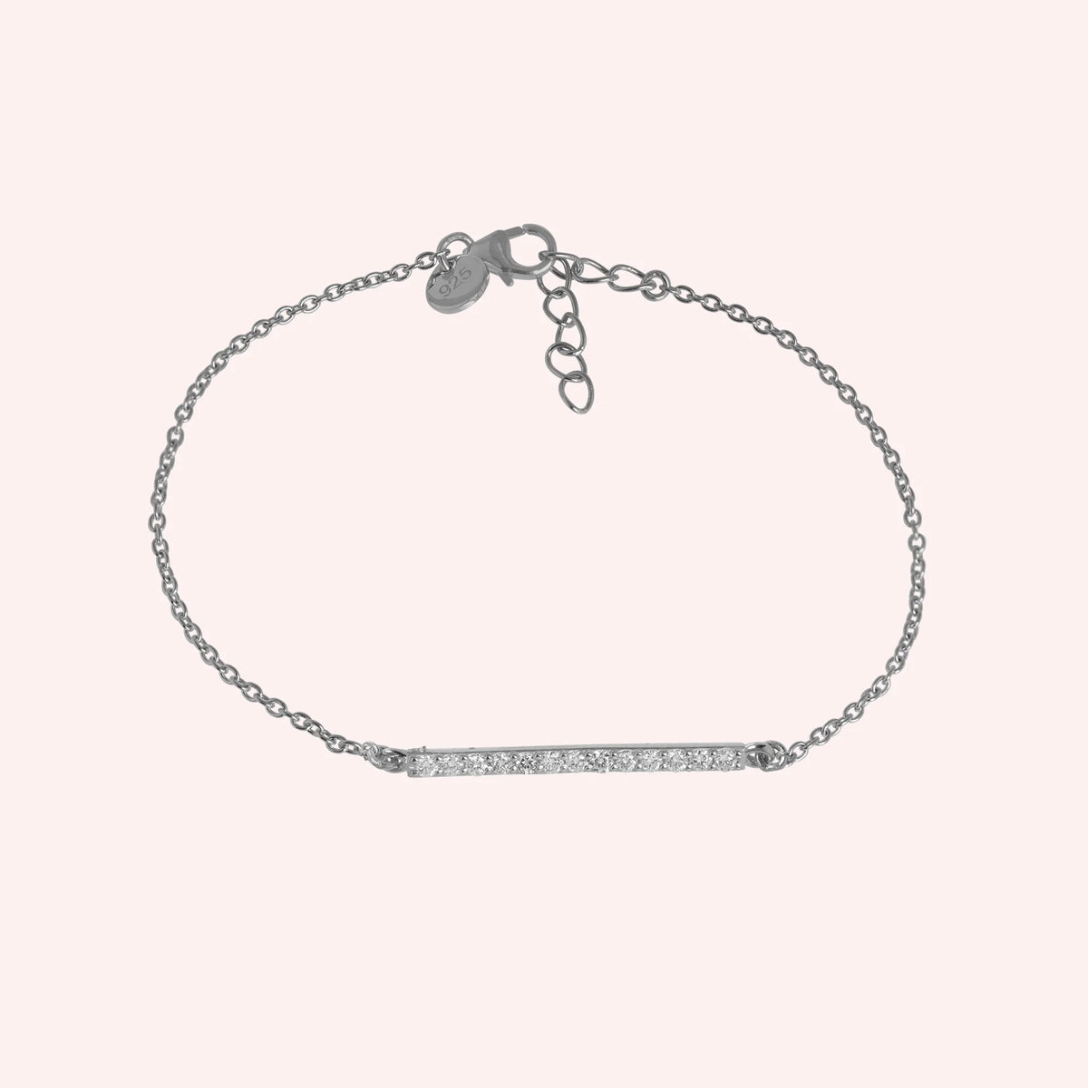 Stone_bracelet_in_sterling_silver_in_a_bar_design_with_CZ_stones_at_front_angle_view_on_solid_pink_background