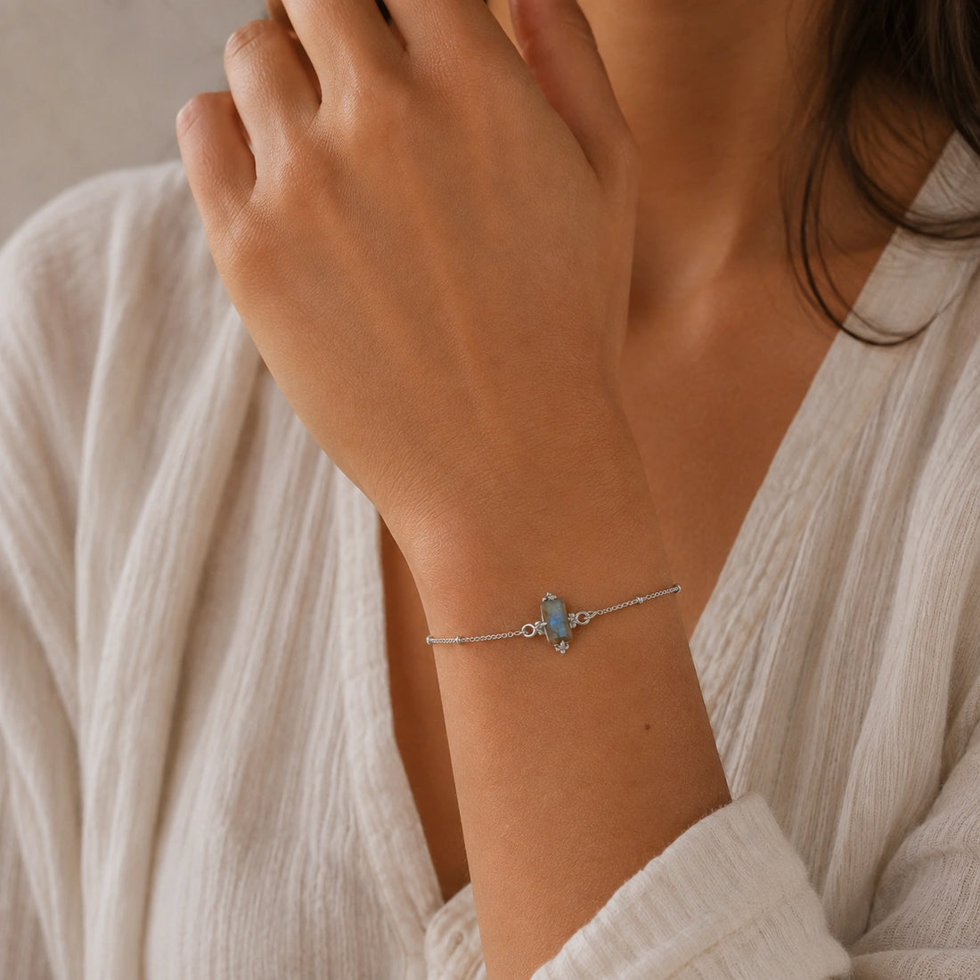 Stone_bracelet_in_gold_plated_silver_with_a_baguette_labradorite_at_front_angle_view_on_soft_fabric_background