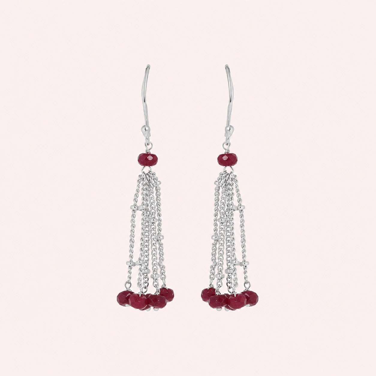 Tassel_earrings_in_sterling_silver_with_chain_and_ruby_stones_at_front_angle_view_on_solid_pink_background