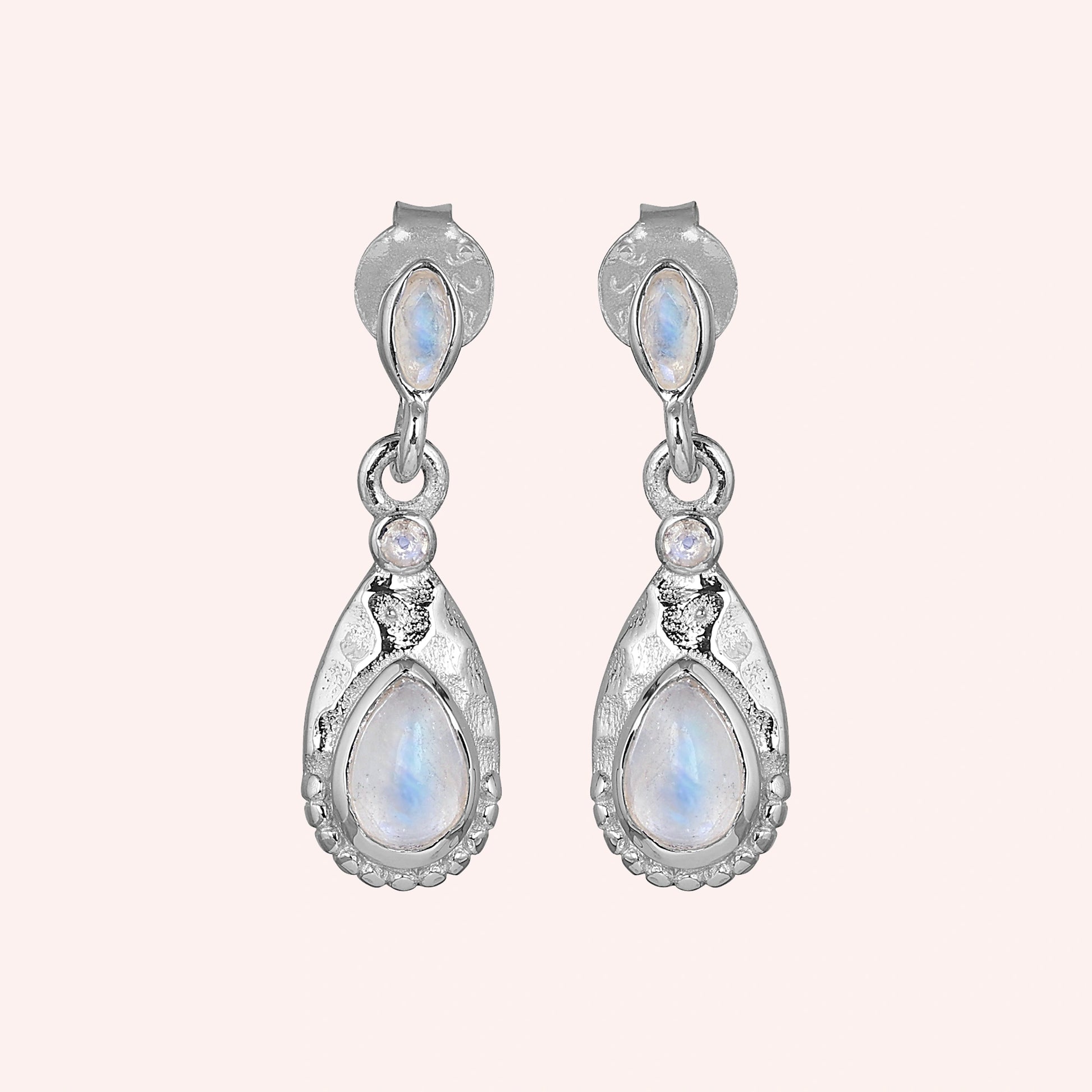 Teardrop_earrings_sterling_silver_with_moonstone_in_front_angled_view_on_solid_pink_background