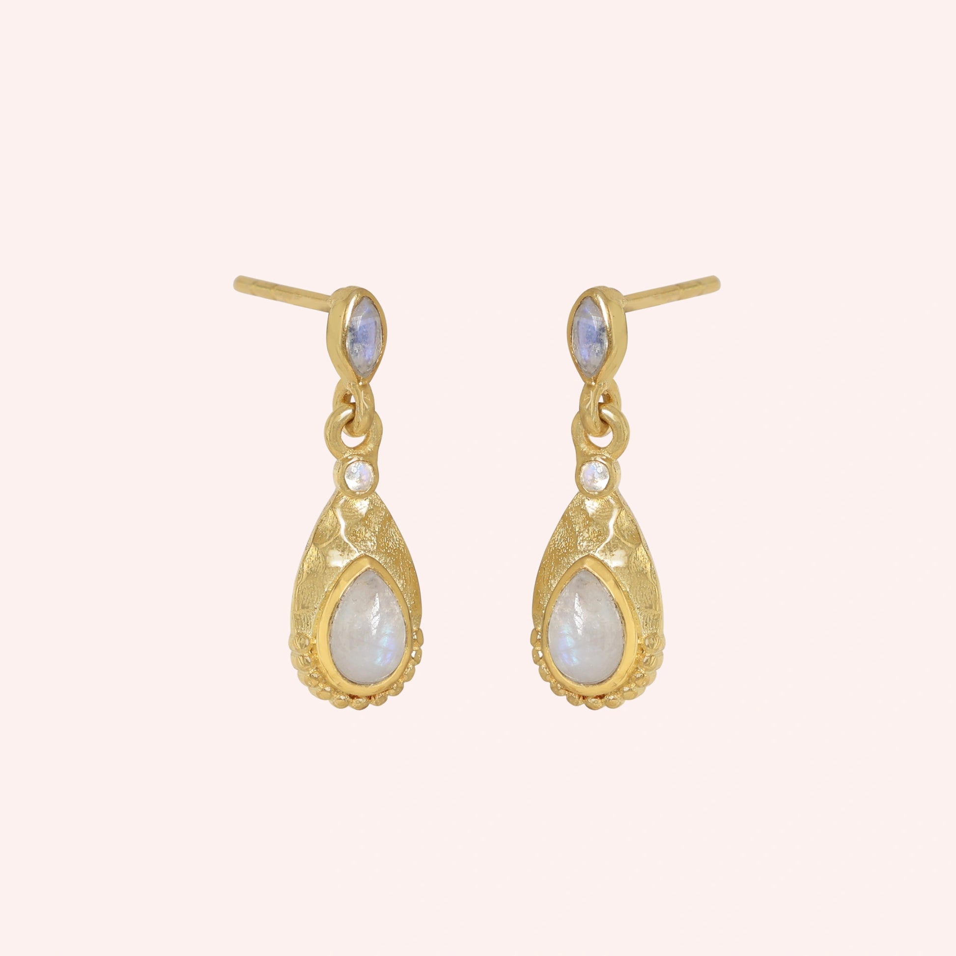 Teardrop_earrings_gold_plated_silver_with_moonstone_in_slightly_angled_view_on_solid_pink_background