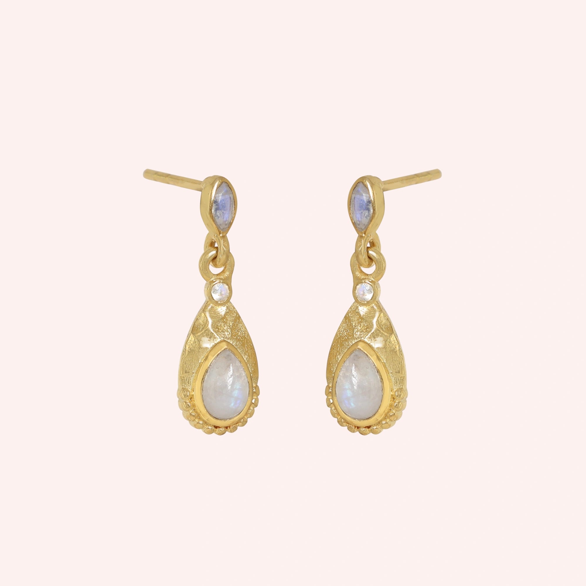 Teardrop_earrings_gold_plated_silver_with_moonstone_in_slightly_angled_view_on_solid_pink_background