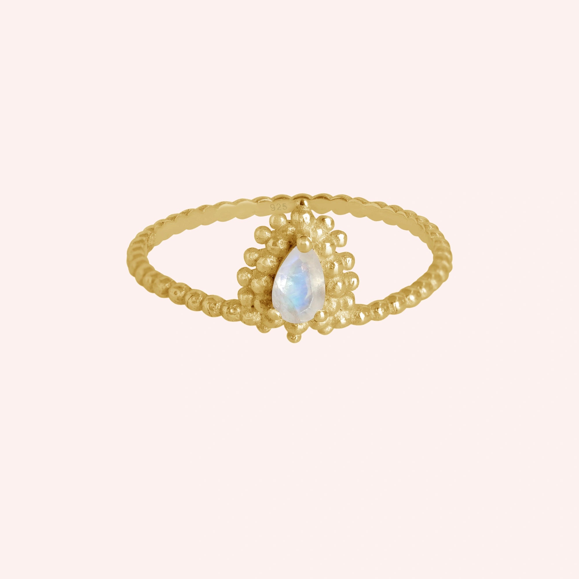 Teardrop_ring_gold_plated_silver_beaded_band_with_moonstone_at_front_angle_view_on_solid_pink_background