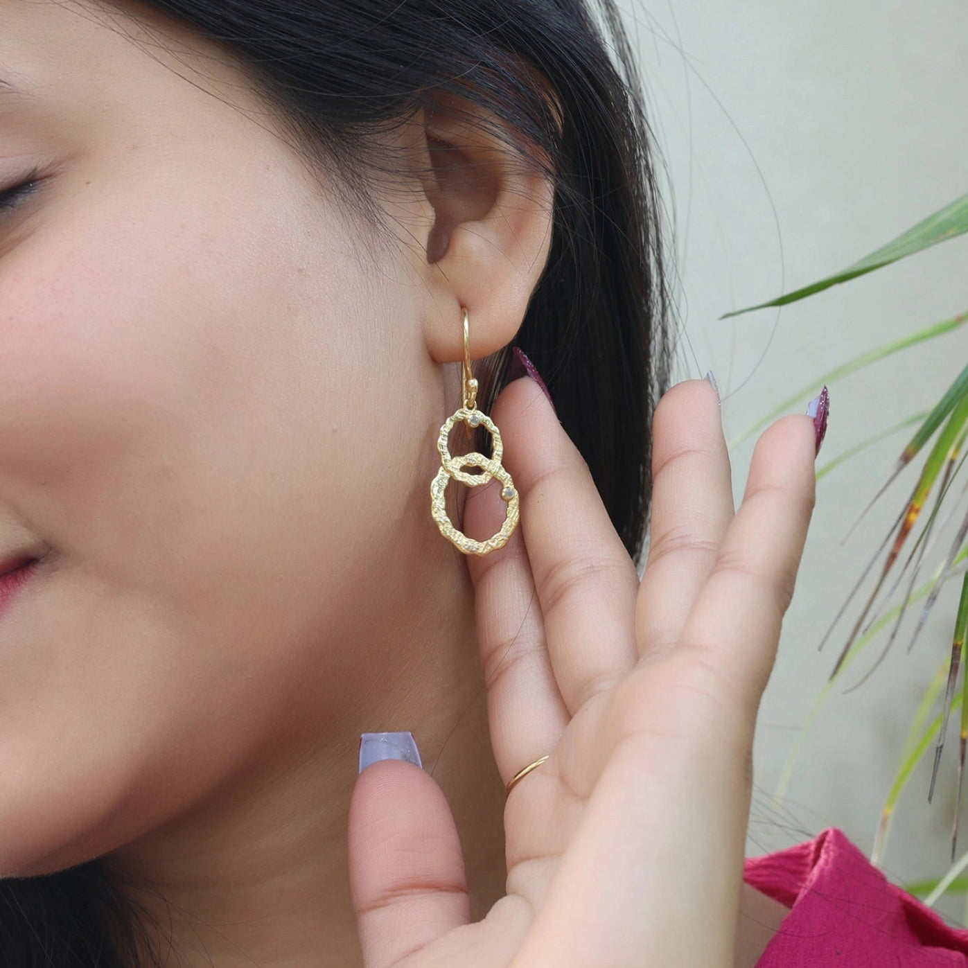Silver dangle earrings look shown by model wearing gold-plated interlocking rings with small labradorite stones in an outdoor shot