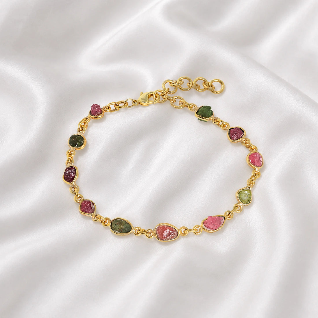 Tourmaline_bracelet_with_rough_tourmaline_stones_in_gold_plated_silver_at_front_angle_view_on_soft_fabric_background