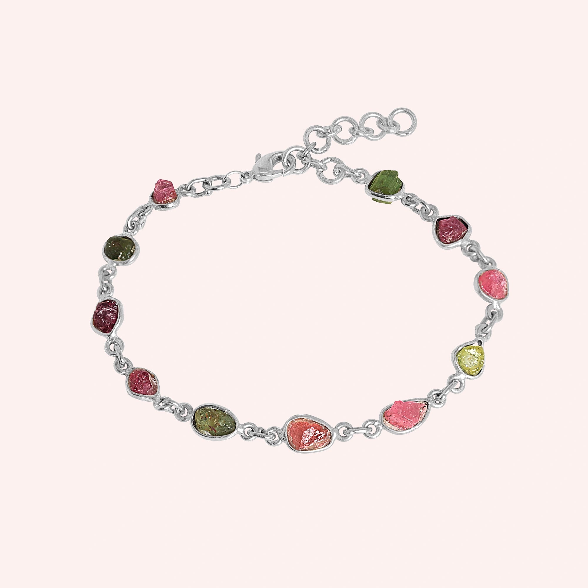 Tourmaline_bracelet_with_rough_tourmaline_stones_in_sterling_silver_at_front_angle_view_on_solid_pink_background